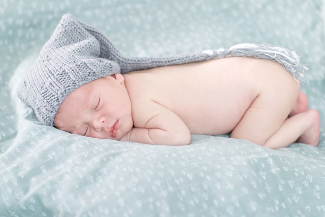 Babyfotoshoot en Zwangerschapsshoot new-born op een brauw deken tijdens studio fotoopnames.